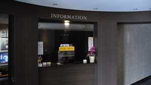 A reception desk with a sign that reads "INFORMATION" and a flower vase. - Motel Daeha (Seoul)