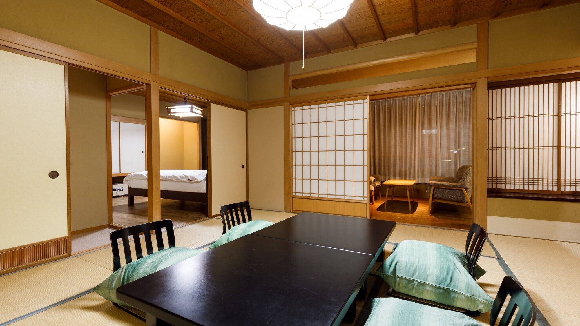 Una habitación japonesa tradicional con suelo de tatami, una mesa baja y puertas correderas shoji.