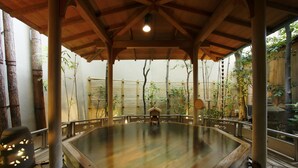 A hot spring bath area with a wooden deck and bamboo fence. - Hatori (Kaga)