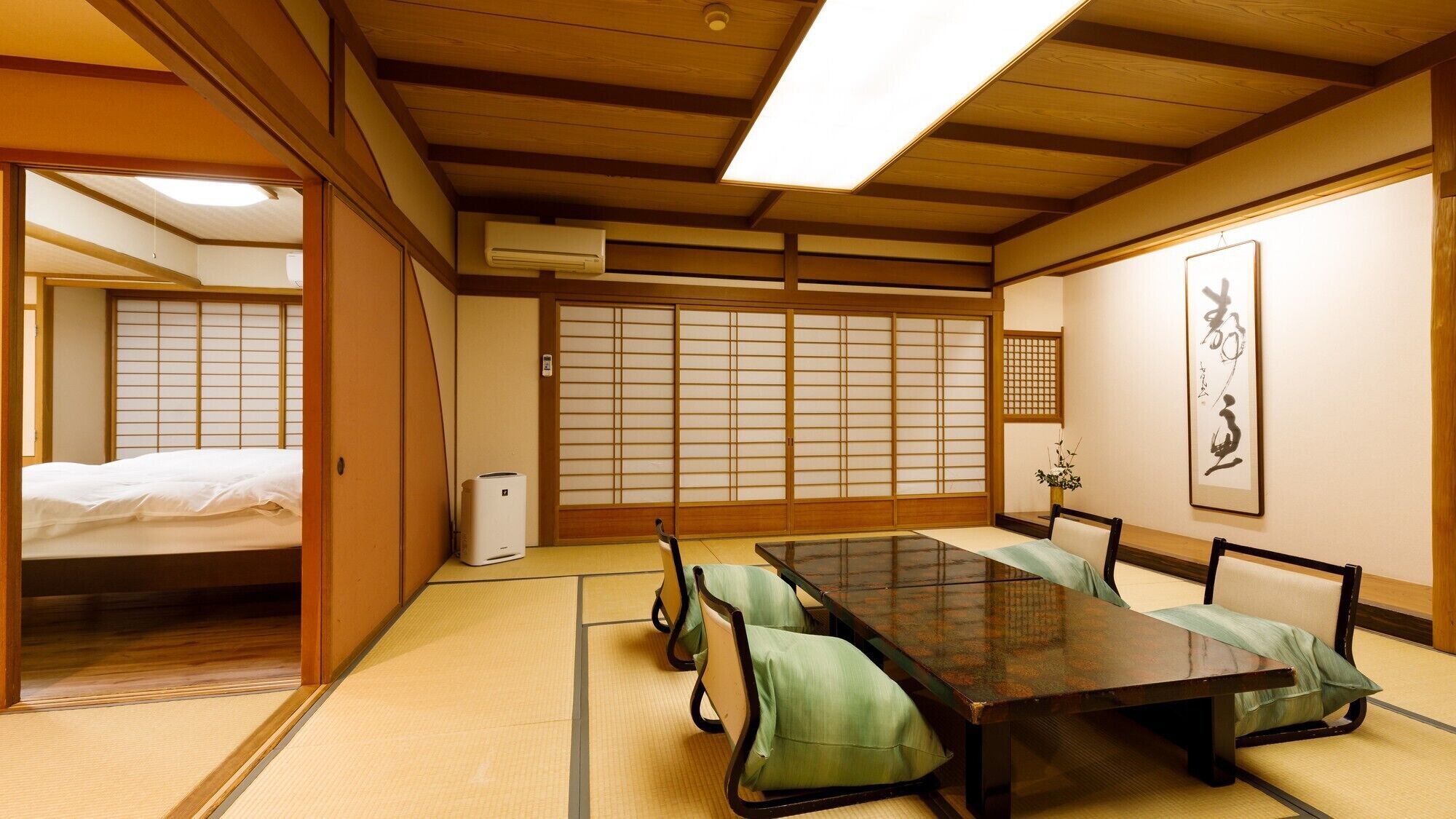 Una habitación japonesa tradicional con suelo de tatami, una mesa baja y puertas correderas shoji.