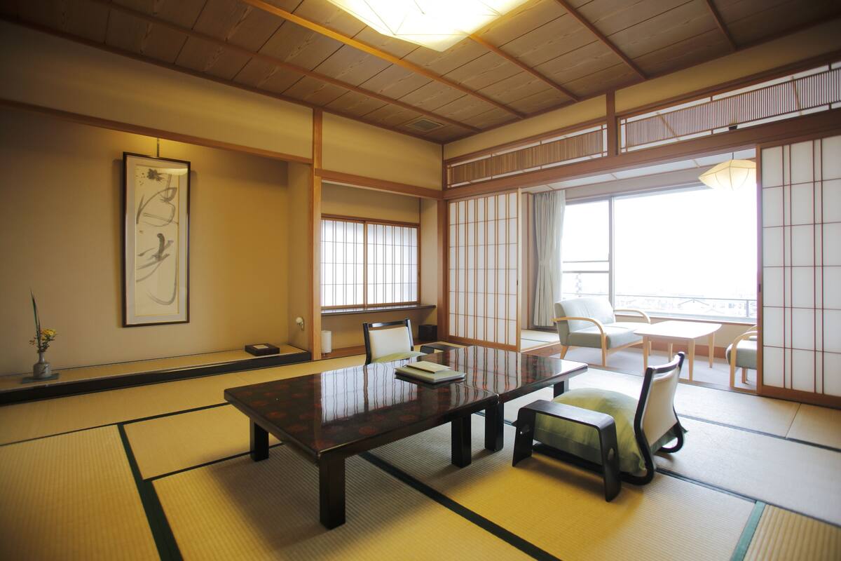 Una habitación japonesa tradicional con suelo de tatami, una mesa baja y paneles shoji.