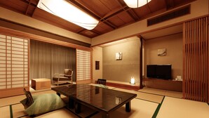 A traditional Japanese room with tatami flooring, a low table, a television, and sliding doors. - Hatori (Kaga)