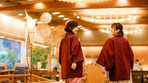 A restaurant interior with wooden furniture and hanging lights. - Hatori (Kaga)