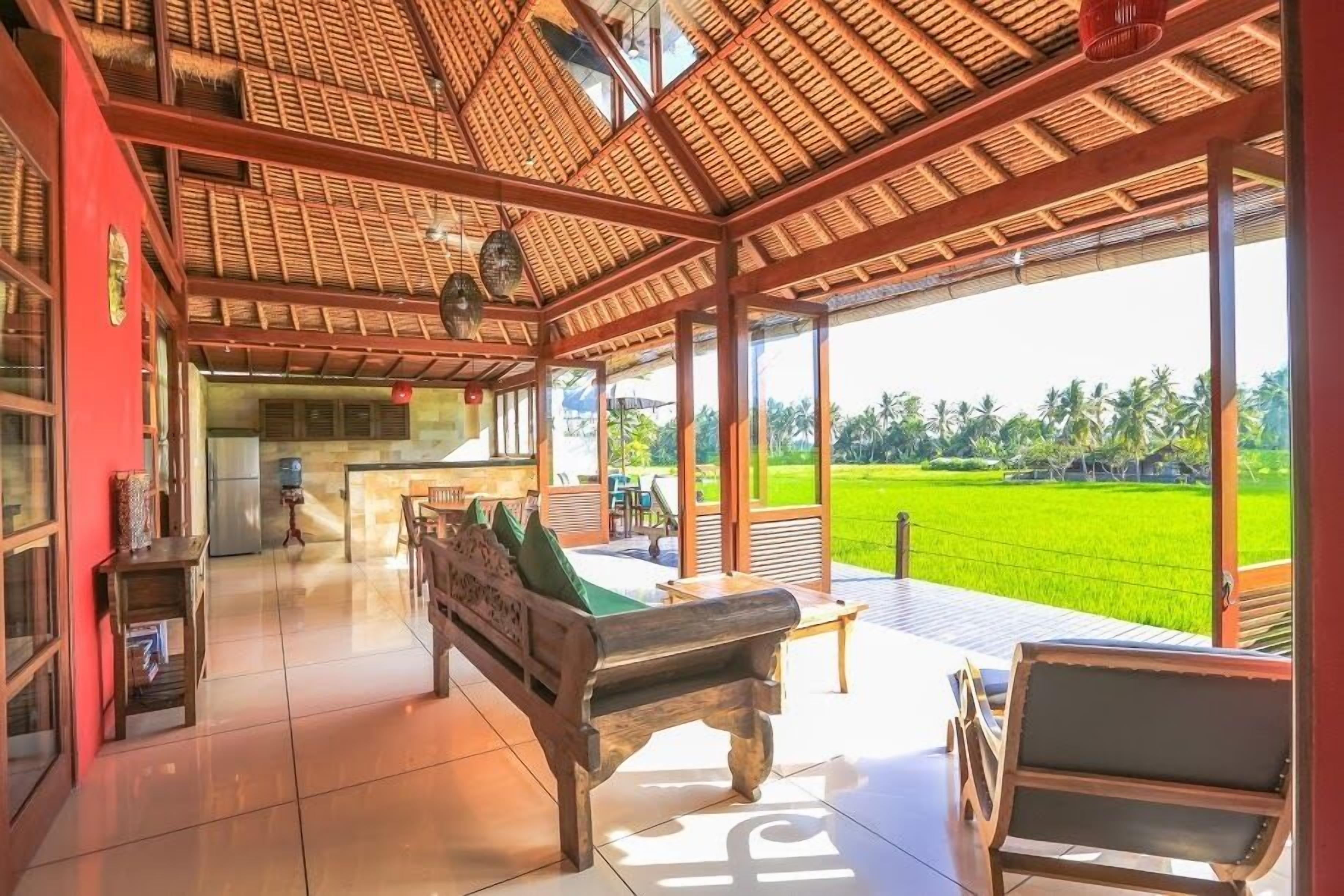 A spacious living area with a wooden ceiling, a dining table, and a sofa.