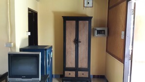 A room with a television, a cabinet, and a wall-mounted electrical box. - Lucky Home Resort (Koh Samui)