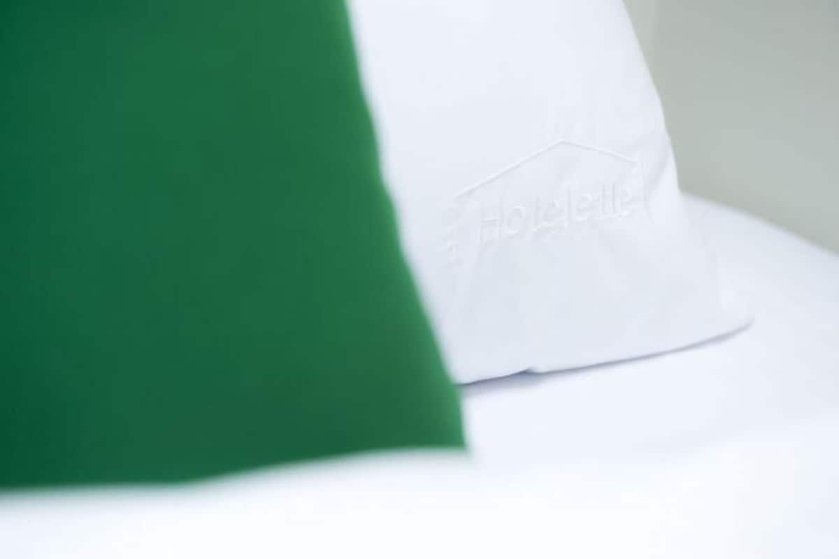 A pillow with a hotel logo on it.