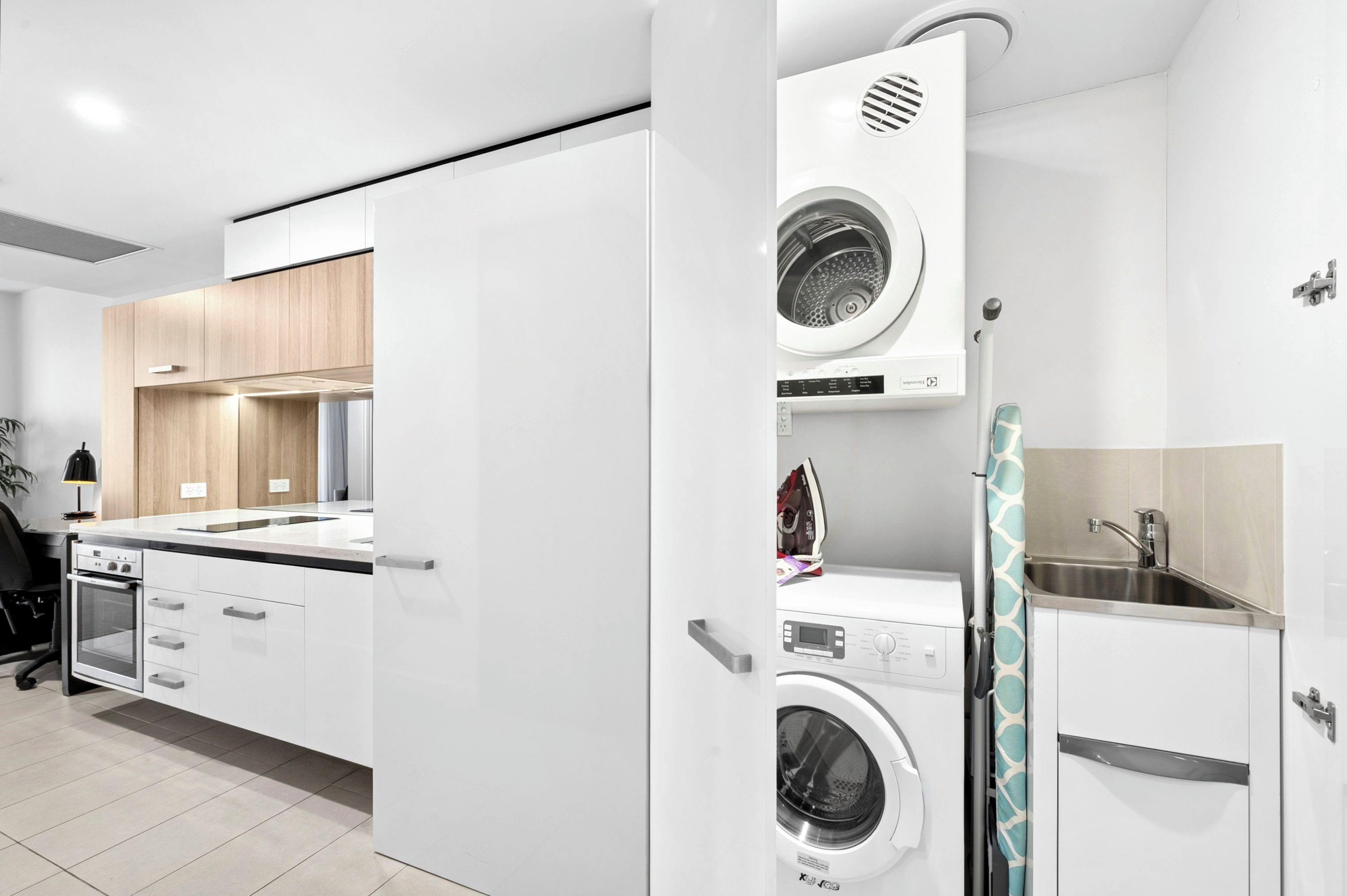 A modern kitchen with built-in appliances, including a washing machine and an oven.