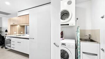 A modern kitchen with built-in appliances, including a washing machine and an oven.