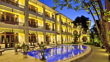 Una piscina al aire libre, sombrillas, tumbonas