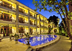 A multi-story hotel with a swimming pool, outdoor seating, and a well-lit facade. - Hoi An TNT Villa (Da Nang)