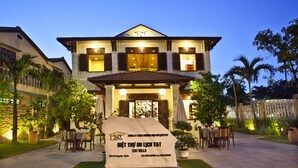 A two-story building with a sign in front. - Hoi An TNT Villa (Da Nang)