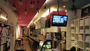 Et hotellobby med barområde, loungeområde og en udstilling af håndklæder.
