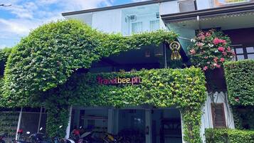 Un edificio con un cartel que dice 'Travelbee.ph' y una motocicleta estacionada adelante.