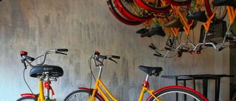 A bicycle storage area with multiple bicycles, including a yellow one with a red frame.