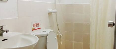 Ein kleines Badezimmer mit Toilette, Waschbecken und Dusche.