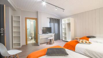 Una habitación de hotel con cama, escritorio, silla y armario.
