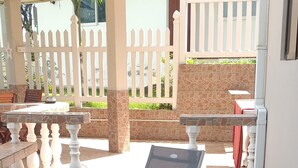 Eine Holzterrasse mit zwei Liegestühlen, jeweils mit einem blau-weißen Handtuch.