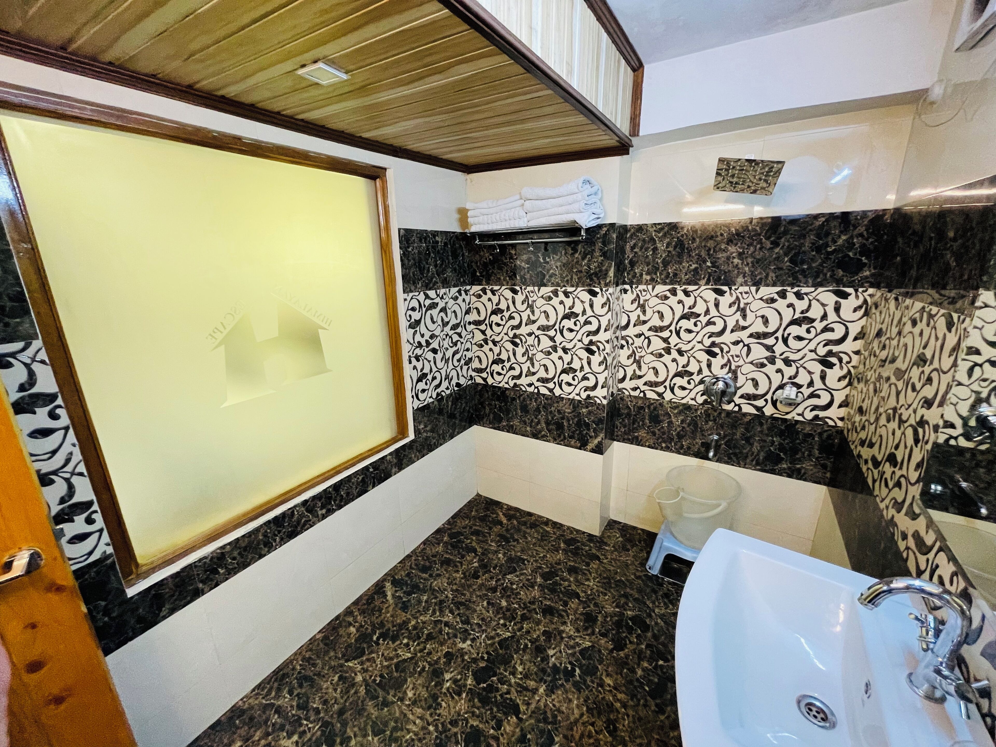 Une salle de bain avec un sol en marbre, un lavabo et un espace douche.