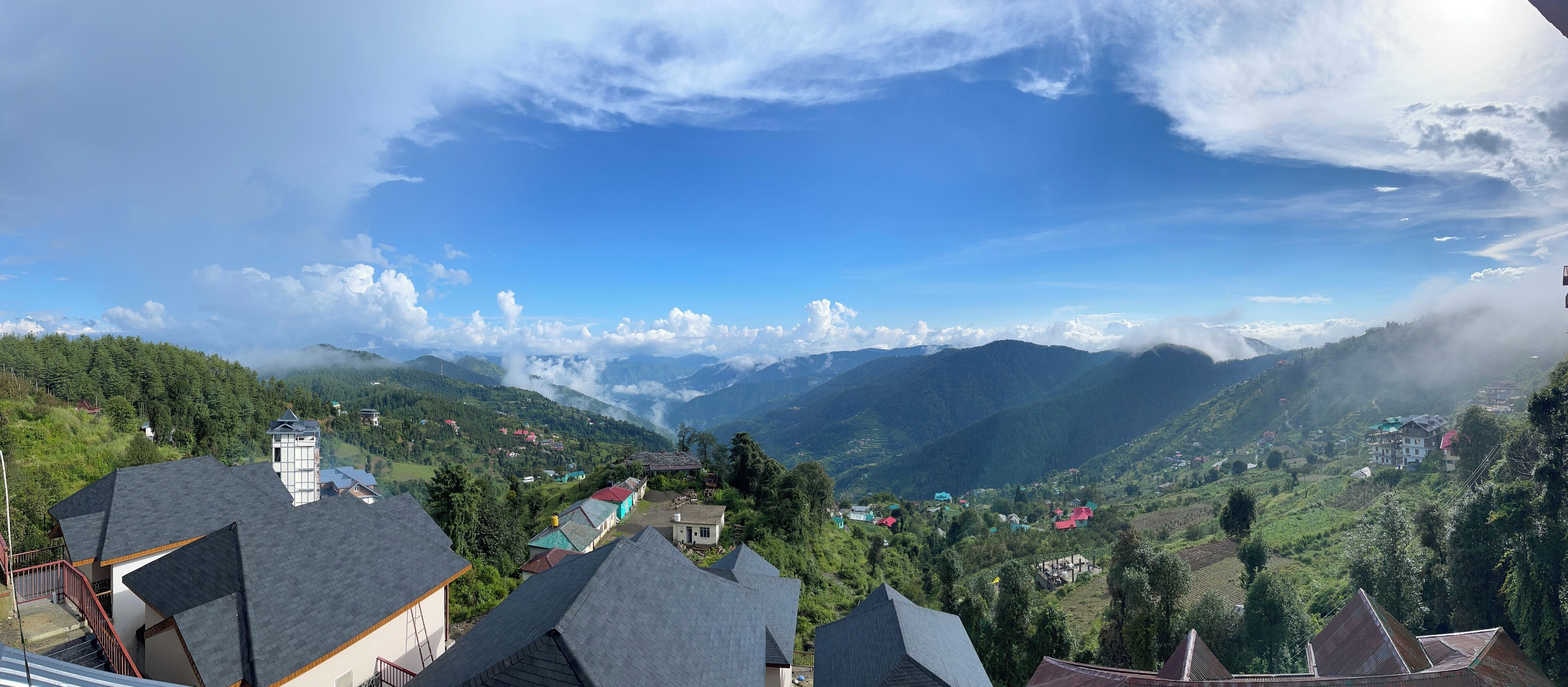 A panoramic view of a mountainous village with traditional houses and a clear sky.
