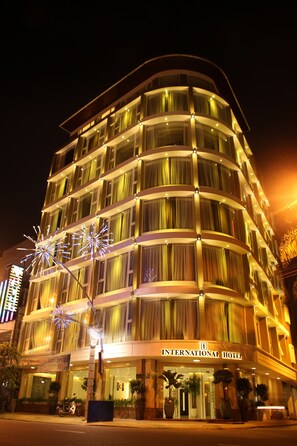 A multi-story hotel with a curved facade, large windows, and a sign reading "INTERNATIONAL HOTEL". - International Hotel (Can Tho)