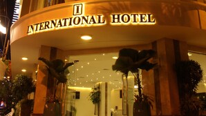 A multi-story hotel with a curved facade, large windows, and a sign reading "INTERNATIONAL HOTEL". - International Hotel (Can Tho)