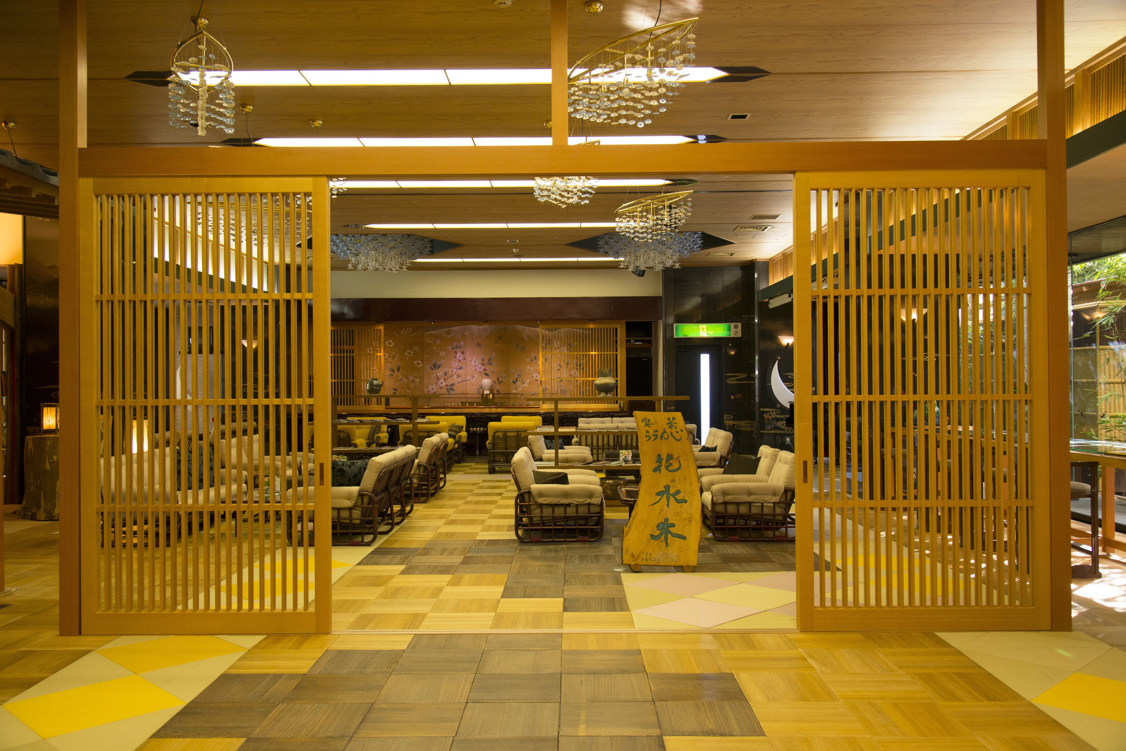 Una habitación de estilo japonés tradicional con suelo de tatami, mesas bajas y sillas.