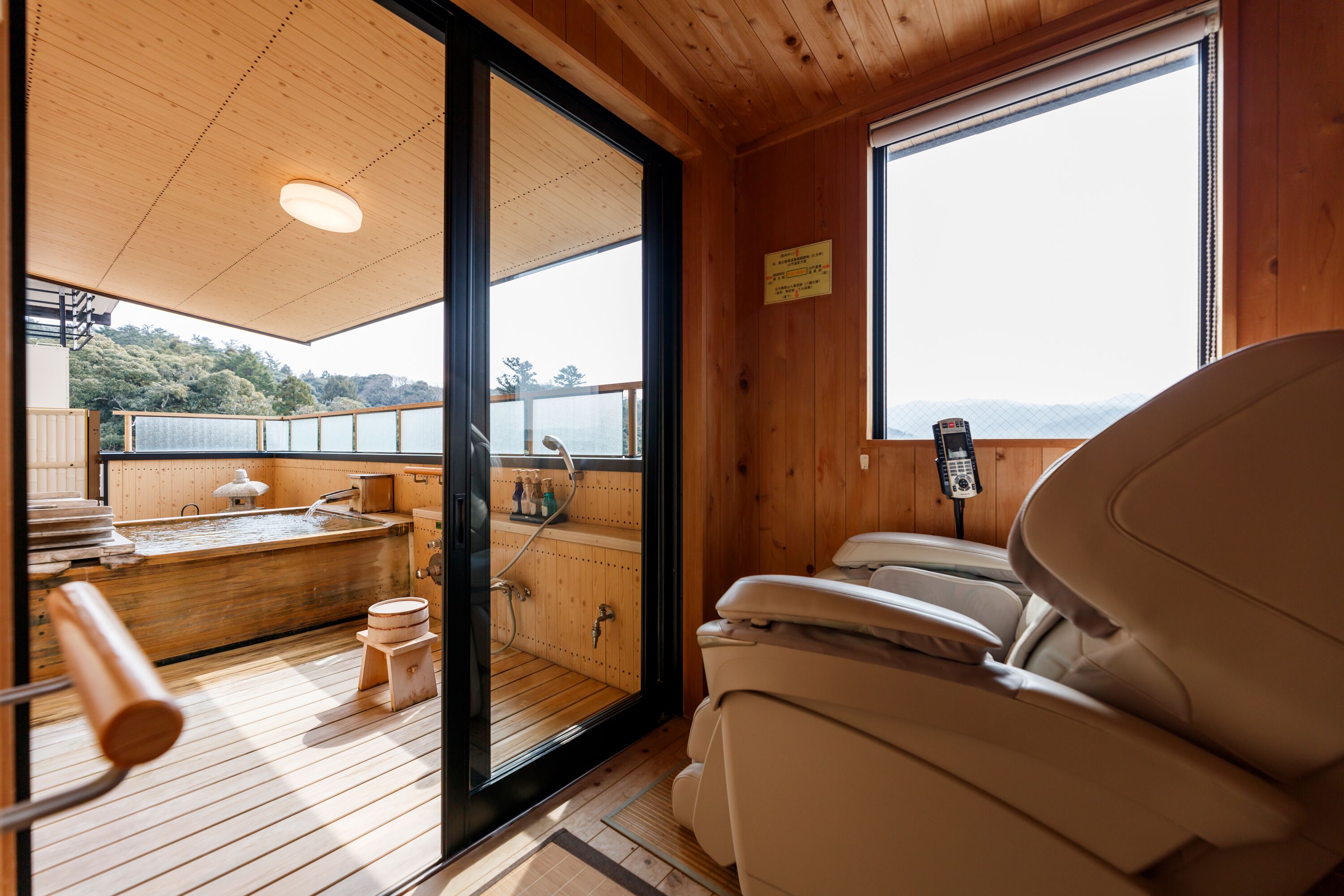 A wooden cabin with a sauna, a hot tub, and a massage chair.