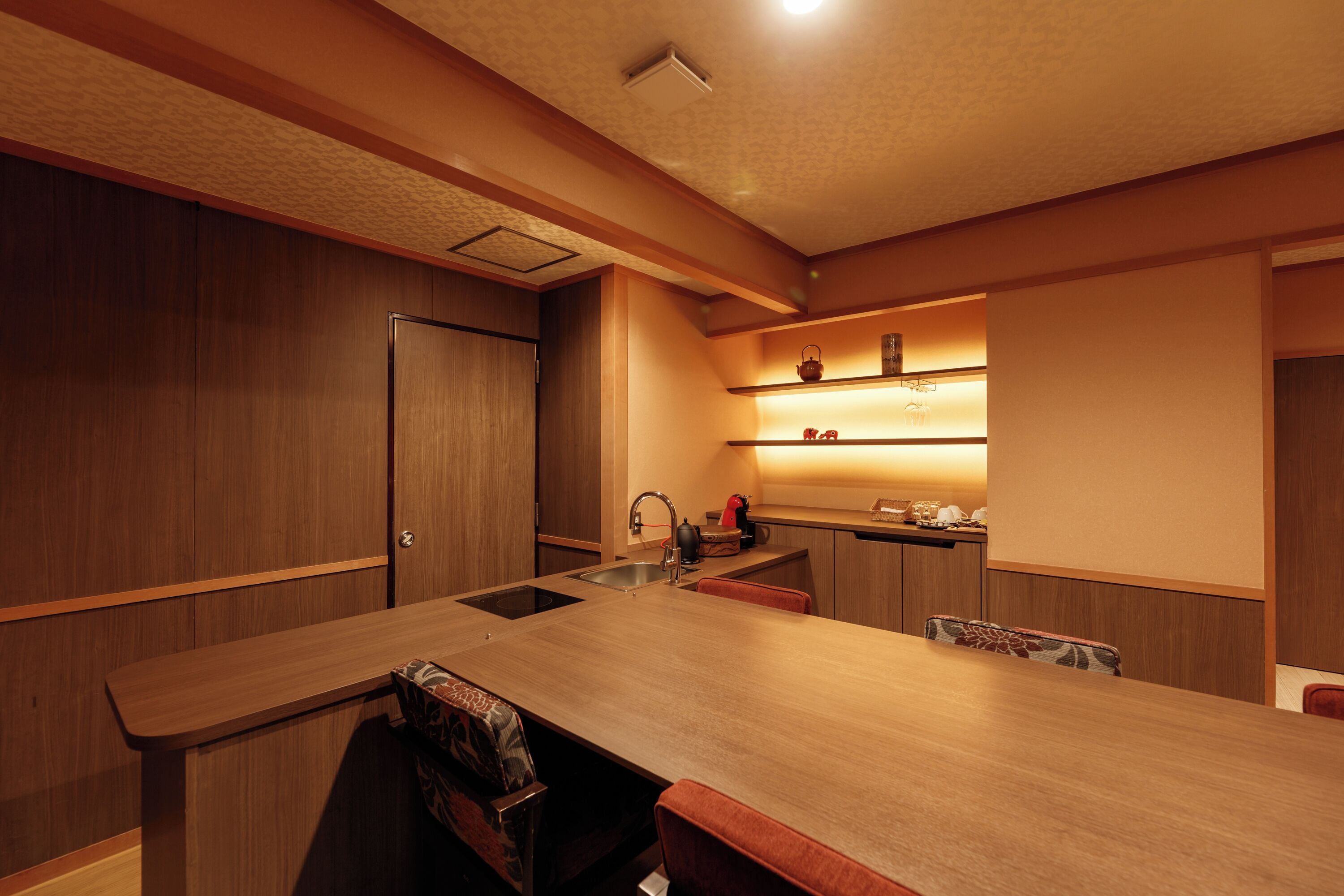 A modern kitchen with a wooden countertop, a sink, and a built-in oven.