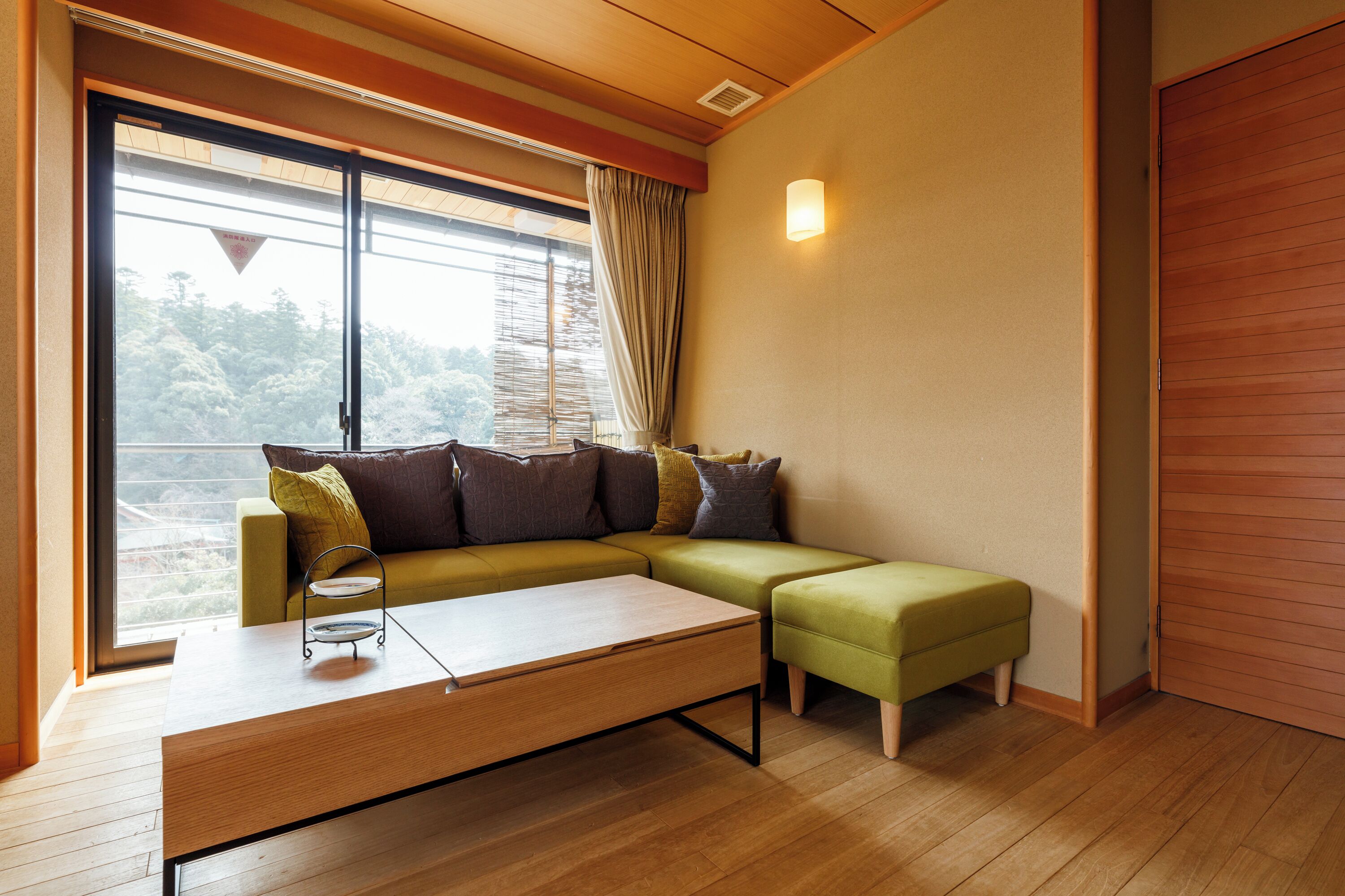 A modern living room with a sectional sofa, a coffee table, and a sliding door.