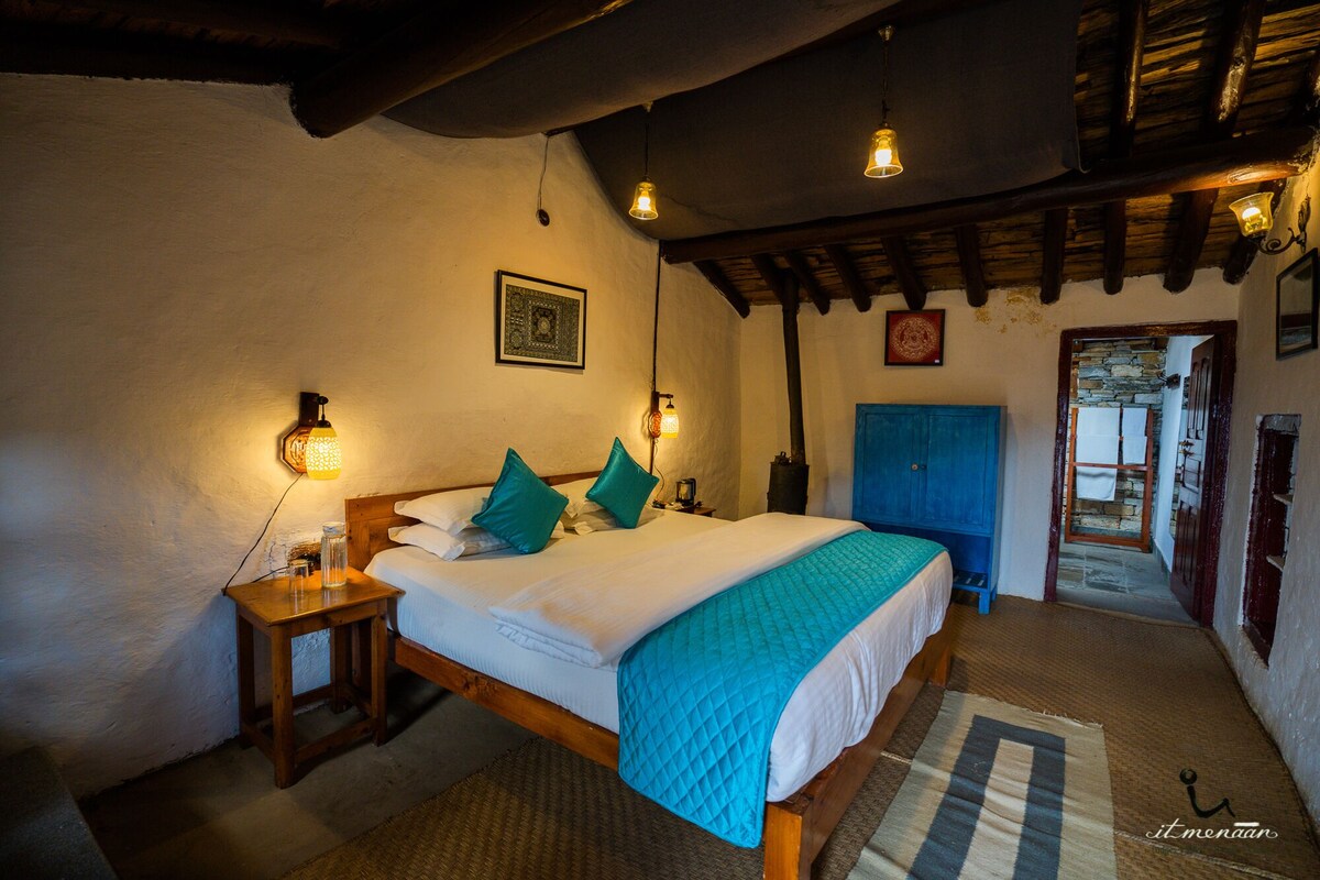 Ein gemütliches Schlafzimmer mit einem hölzernen Bett, zwei Nachttischen und einer blauen Tür.