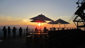 A sunset view from a wooden deck with umbrellas and tables. - Shimaya (Yamanouchi)