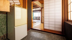 A traditional Japanese room with tatami flooring, a sliding shoji door, and a low wooden cabinet. - Shimaya (Yamanouchi)