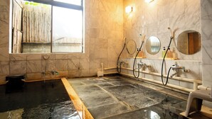 A modern bathroom with a large soaking tub, marble walls, and a window with bamboo curtains. - Shimaya (Yamanouchi)
