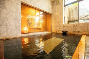 A spa area with a large wooden sliding door, a small wooden bench, and a tiled floor. - Shimaya (Yamanouchi)