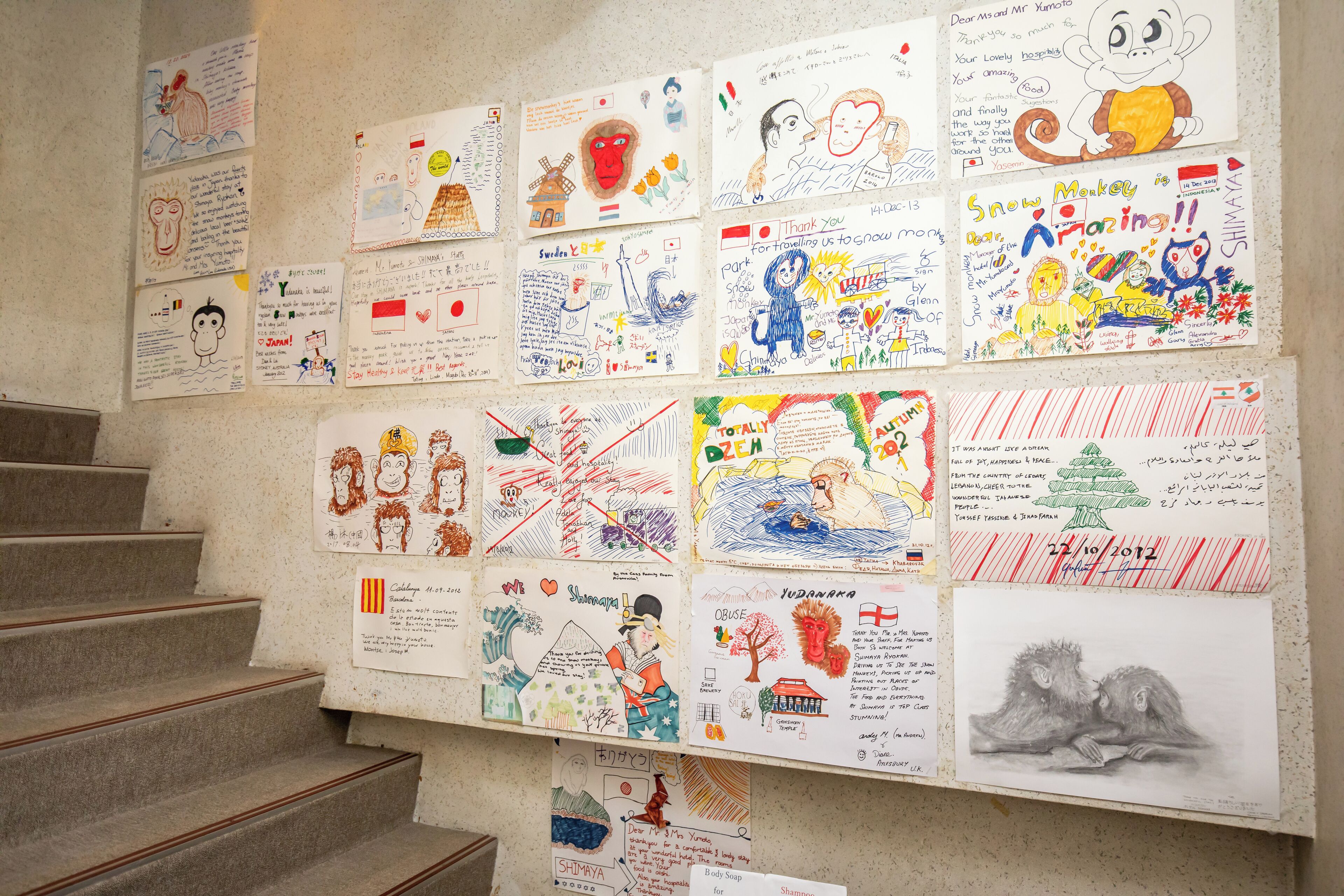 A wall with various drawings and writings, including a monkey, a tree, and some text.