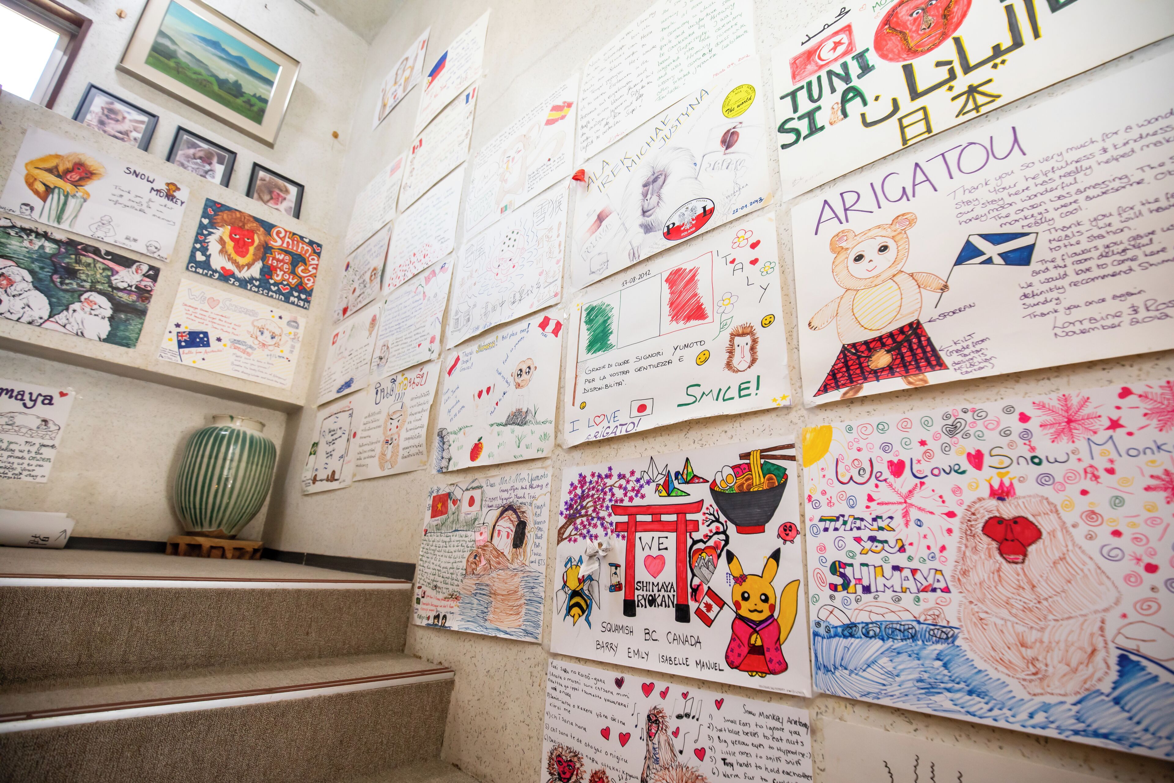 Un mur recouvert de dessins et d’inscriptions d’enfants, notamment un ours, un singe des neiges et divers autres personnages.