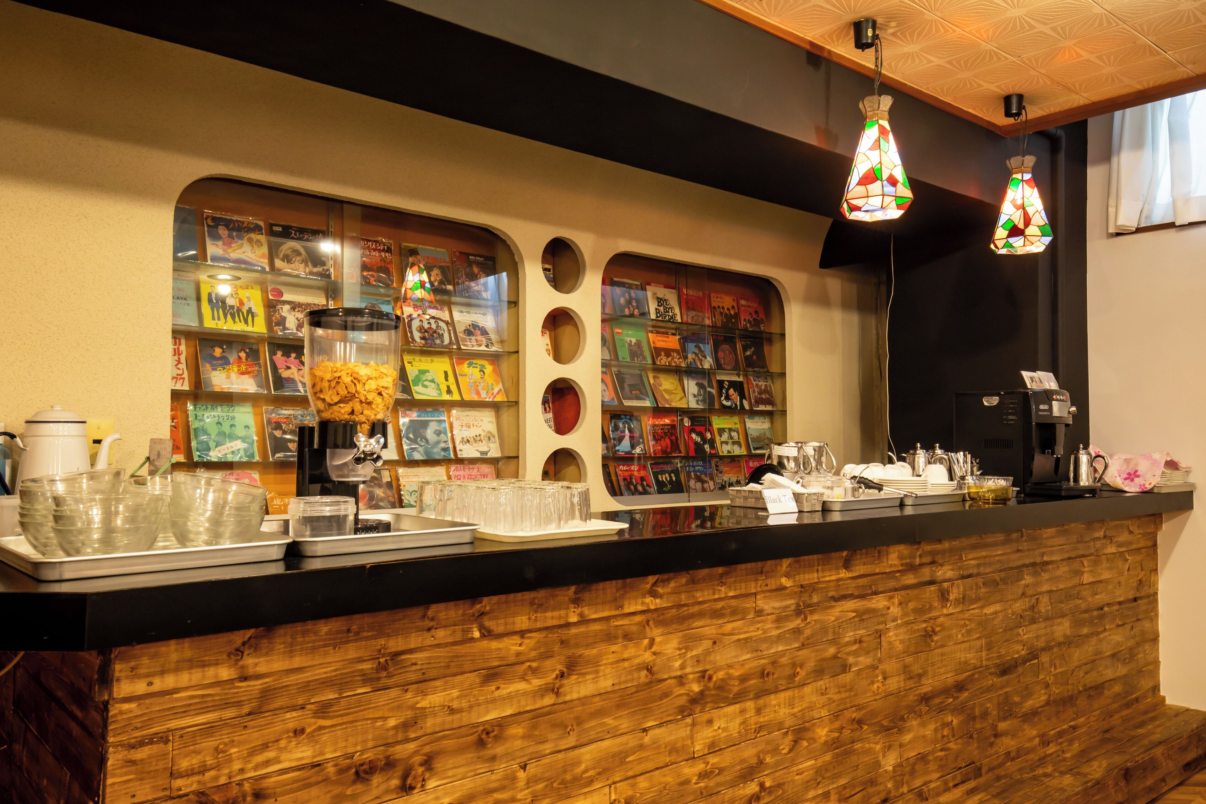 Mostrador con vitrinas de libros, una cafetera y un diseño de paneles de madera.