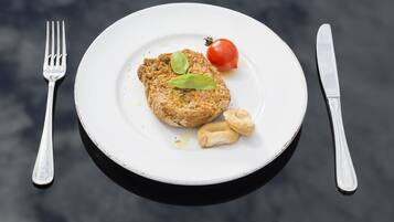 A plate with food, a fork, and a knife on a table.