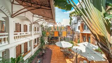 An indoor courtyard with a covered seating area, outdoor dining, and a view of the surrounding buildings.