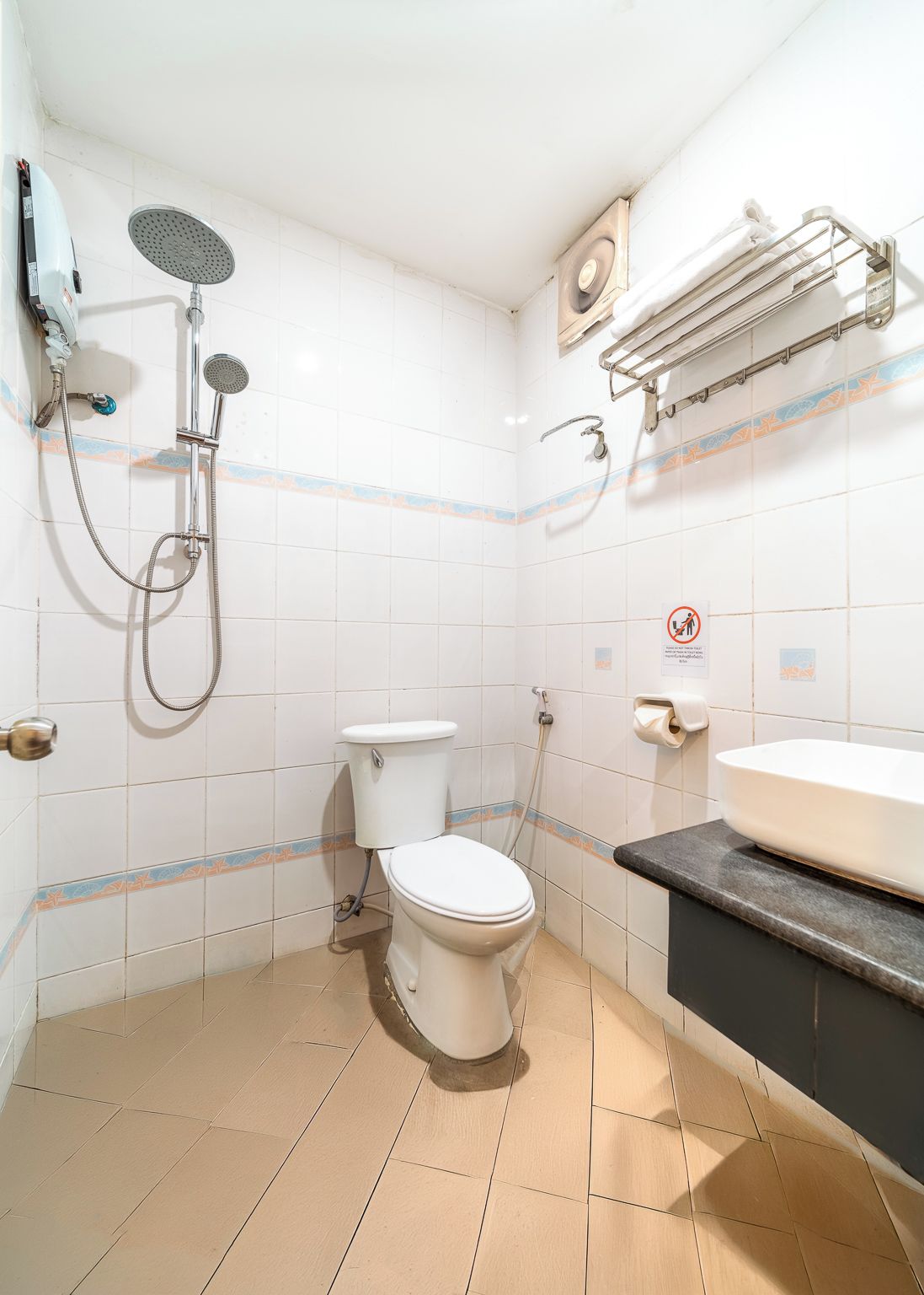 Un baño con inodoro, ducha y lavamanos.