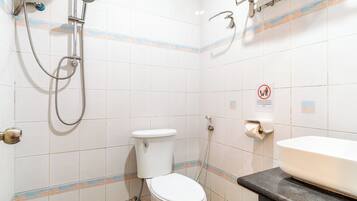 Un baño con inodoro, ducha y lavamanos.