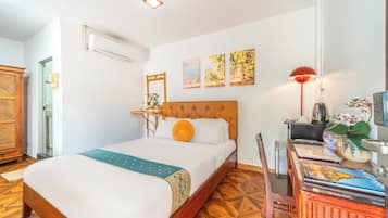 Una habitación de hotel con una cama, un escritorio con lámpara y una silla.