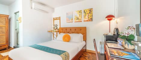 Une chambre d’hôtel avec un lit, un bureau doté d’une lampe et une chaise.