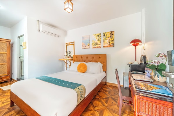Une chambre d’hôtel avec un lit, un bureau doté d’une lampe et une chaise.