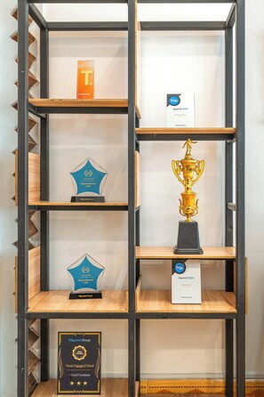 Una exhibición de premios en una estantería metálica.