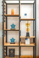 A display of awards on a metal shelving unit.