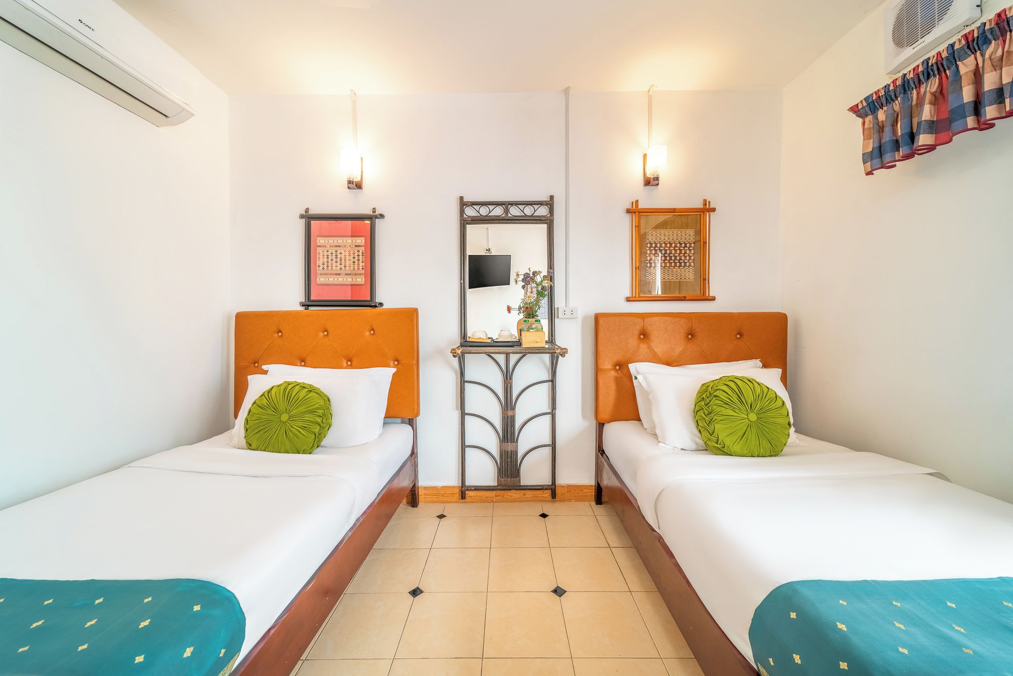 Ein Hotelzimmer mit zwei Betten, einem kleinen Tisch und einem Spiegel.