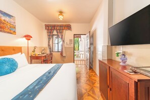 A hotel room with a bed, a desk, a television, and a view of the outside. - Mali Namphu Hotel (Vientiane)