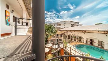 A hotel with a pool, outdoor seating, and a view of the surrounding buildings.