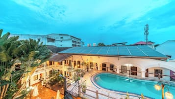 Un hotel con piscina, mobiliario exterior y vistas de los edificios circundantes.
